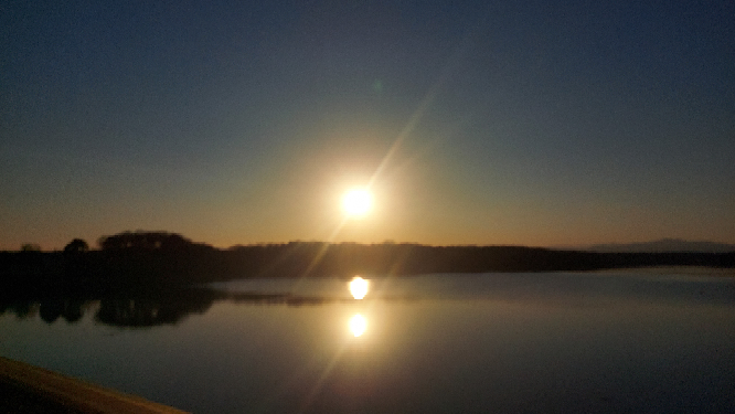 湖に夕日をみにいったのですが、 太陽が2つ鏡面していました。完全に落ちる10分前は1つになったのですが、まだ高い位置にある時2つ映し出されることはありますか？ どういう仕組みなのか教えて欲しいです。