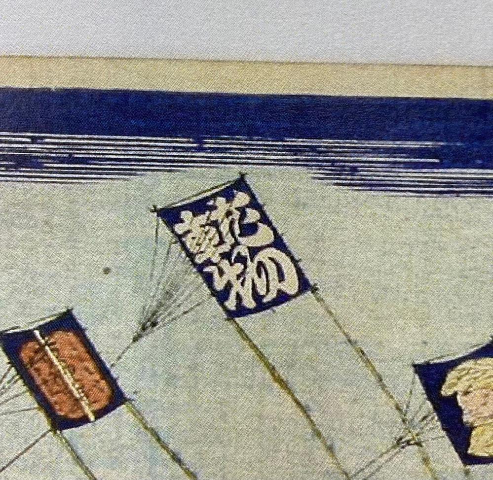 風刺画について質問です。 写真中央の凧に書かれている漢字、読み方、意味を教えてください。