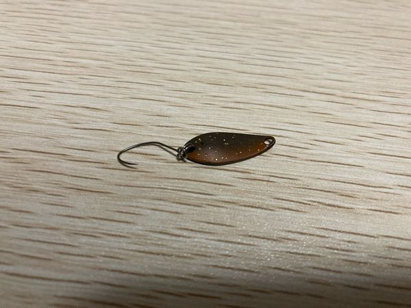 写真のスプーンのカラー名がわかる方がいらっしゃいましたら、ご教授願います。 ヴァルケインのシャイラ1.2gなんですが、カラー名がわからず困っています。どこかのお店のオリジナルカラーなのでしょうか？ 表はブラウンに蛍光オレンジをサイドに塗ってある感じで、ラメがついています。 裏は光らない金のような感じです。 どうぞわかる方いらっしゃいましたら回答お願いします。