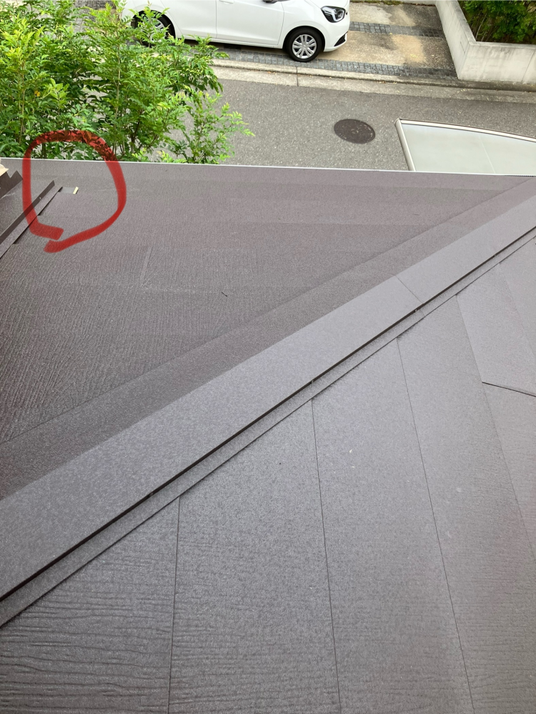 スーパーガルテクトの施工について質問です。
自宅の屋根にスーパーガルテクトの施工を、リフォーム業者にして貰いました。 仕上がり自体はとても満足しているのですが、屋根の平面に、ある部品がはみ出していて、はみ出した部品の端から紙の様な素材が露出しており気になっています。(写真の赤丸部分です)
隅棟(知識がないもので名称間違えていたらすみません)の延長線上の部品が屋根の平面にはみ出している感じ...