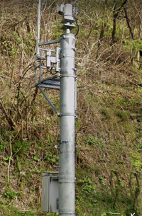 峠道にあるこのカメラのようなものはなんでしょうか？10mくらい離れたところに下向きのセンサーのようなものがあります 