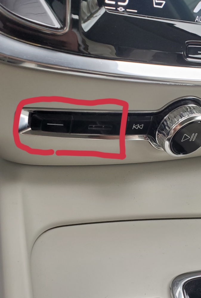 車のセンターディスプレイ下のこの赤枠で囲ってある部分は何の為に使うのでしょうか？ 左側の－みたいな部分は蓋が外れるようですがよく分かりませんでした。 右側は何かの差し込み口？に見えます。 よろしくお願いします。