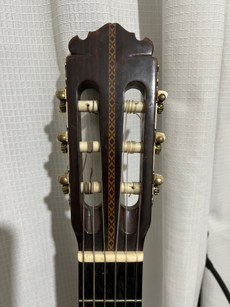 クラシックギターについて質問です。 音が良く購入した古いクラシックギターですが、メーカー等の表記が全く無く、どなたか詳しい方がいたら教えてほしいです。 ヘッドの形状から判断できる方いらっしゃいますか？ 他の特徴としては、トップは単板、指板は黒檀のようにみえます。