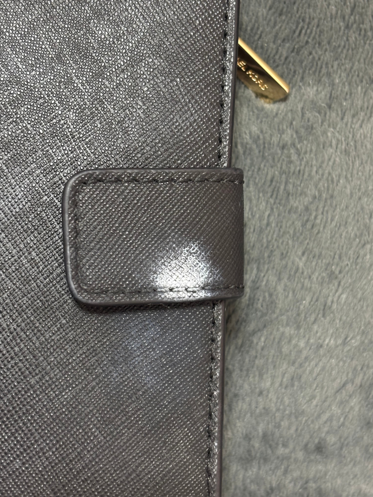 至急です。アロンアルファをつけたものを財布の上においておいたら、白くなってしまいました。この白いのはなんでしょうか、、、 アルコールシートで拭いたら一時的に綺麗になりましたが、少ししたら元に戻ってしまいました。 お金を貯めて初めて買ったお財布なのですごくショックです。この白いものを落としたいです。対処法教えて頂きたいです。 また、最終手段ですが、自分で何しても落ちなかった場合MICHEAL KORSで購入したのですが、店舗に持っていけば綺麗にして頂けますか？？