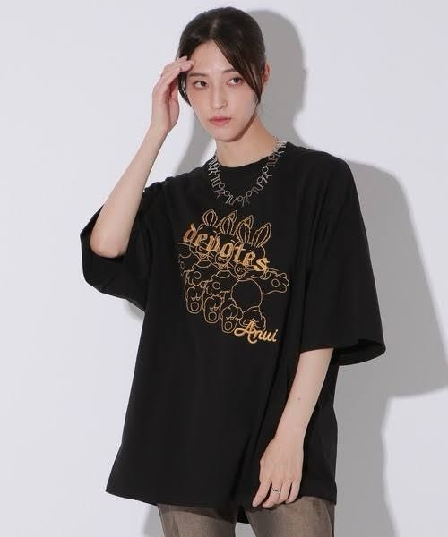写真のような黒基調で胸元に大きくオレンジのデザインがある半袖服教えて欲しいです