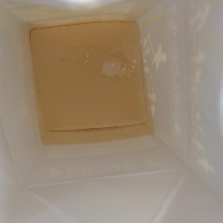 廃油石けんの分離について。 2/10に廃油石けんを作りました。 キャノーラ油 1000g 水 370g 苛性ソーダ 140g 水でしっかり苛性ソーダを溶かし、60℃に温めた油を混ぜたのですが 途中で苛性ソーダ水を大さじ3～5くらいこぼしてしまいました。 苛性ソーダを足してアルカリが残るより油が多い方がましかと思いそのままペットボトルで攪拌。 1時間半程タプンタプンと揺らしたのですが、マヨネーズ状にはならず餡かけの餡ぐらいのとろみでしたがこれ以上時間はかけられず分離はしてなかったので牛乳パック2つに分けて型入れしました。 翌日から分離してまして、明日で１週間でそろそろカットしようと思ったのですが上に5㎜程油が浮いてます(石けんはパックごと押して羊羹くらいの固さっぽいです)。 このまま油を新聞紙などで吸わして捨ててカットして普通に使えるでしょうか？ 写真は傾けて油をみえやすくしてあります。 ちなみに… 油はイベントで１度ドーナツをあげた物。 攪拌は常に動かしてましたが、膝に横向きで乗せて両手で底とキャップを持って上下に揺らしました(バシャバシャと振り混ぜて無い)。 型入れ後の保温を忘れてキッチンのコンロ横に置いてました。最近暖かいので最低気温10℃くらいだと思います。 用途はお皿洗い。 調べてみて塩析をするのが確実だと思うのですが、そのまま使えるなら使いたいです。 石けん作りに慣れたみなさんならこのまま使いますか？