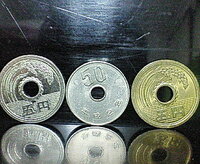 コンビニでお釣りをもらったら銀色？の5円玉をもらいました。何か珍しいものなのでしょうか？ 左の五円玉がその五円玉です。真ん中の50円玉と右の5円玉は比較として置きました。