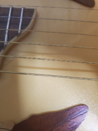 ギターの塗装が割れていました。ギター本体は割れてないみたいです。どうやったら目立たなくなりますか？ 塗装はかなり厚めに塗られているのでクレバスみたいな感じで目立ちます。