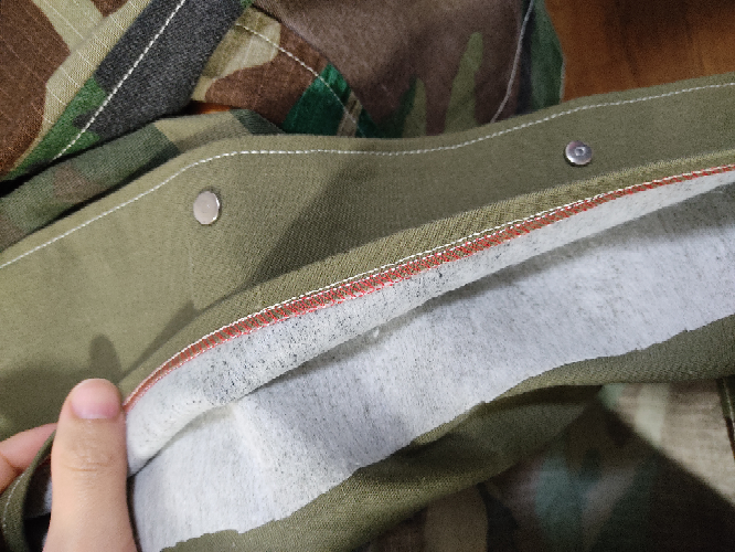 譲っていただいたハンドメイドのテーラードジャケットがあるのですが、前のボタンの裏側を裏返すと接着芯(おそらく不織布)があり、端が少し剥がれていました(端は縫製されていませんでした)。 アイロンをかけると、接着し直しましたが、端が完全には接着しませんでした。 おそらく、この状態で洗濯を繰り返すとそのうち接着芯が剥がれてくると思います。 そのため、接着芯を布用の両面テープやボンドで(緑の)綿の生地、あるいは綿の生地＆合わさる接着芯側の生地に接着してみようか？と思うのですが(縫うと縫い目が表地に出てしまいます)、その処理の仕方で良いでしょうか？また、接着芯と綿の生地、接着芯と接着芯は布用の両面テープやボンドで接着するでしょうか？ご回答をいただけると嬉しいです。