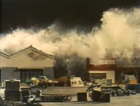 特撮シーンでの津波の高さの質問です。 添付画像は、1974年(昭和49年)TVドラマ『日本沈没』で使用された津波のシーンです。これはおおよそ高さ何メートルの津波というのでしょうか？ 画像左側の倉庫蔵の高さを約６ｍあるものとします。