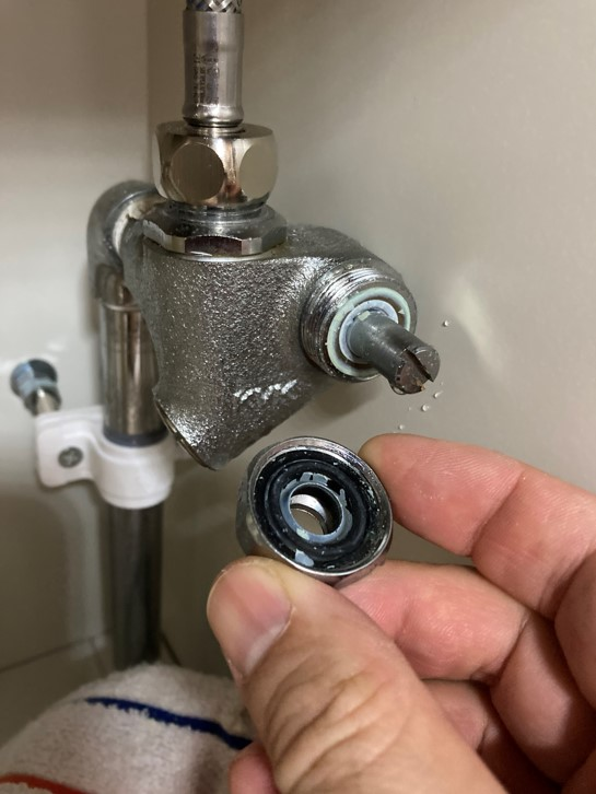 洗面台の下の止水栓からわずかに水漏れしています 画像はネジを外した状態ですが、このネジのあたりから漏れています マイナスで締める部分を引き抜こうとしたんですが抜けません このタイプはコマパッキンなどではないんでしょうか？ 手に持ってる黒いゴムのみを交換すれば漏れは止まるんでしょうか？ どなたか詳しい方、修理方法を教えてください