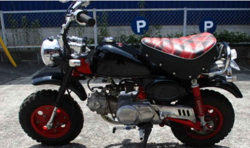 Hondaモンキー50 中華か…？ モンキー50の中古購入を検討している者です。詳しい方知恵をお貸しください。 金額はモンキーにしては相場より若干安く購入できる物です。 ヤフオクなどではなく実店舗のあるバイク屋の商品です。 モデル名や初年全て不明となっていて、走行距離は3233とあります。 修復歴はなしとなっています。 写真を見ると４０周年モデルだと思われるのですが、タンクにHONDAのウィングロゴがありません。 またサイドカバーにも４０周年のロゴがありません。 明日販売店に改めて問い合わせはする予定ではあるのですが、この時点でどういう理由でこのようなパーツが使われているのか分かる方が居れば教えていただきたいです。 また販売店が上手く説明が出来なかった場合、怪しい物だと思って購入を控えるべきでしょうか 宜しくお願いします。