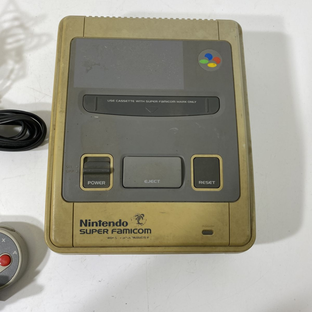 スーパーファミコン本体のデザインについて質問です。 こちらのスーパーファミコンにヤシの木のような模様やnintendo super famicomの字の下に字が見えます。 インターネットで検索しましたが出てきませんでした。ご存じの方いらっしゃったら情報を教えて頂きたいです。よろしくお願いします。