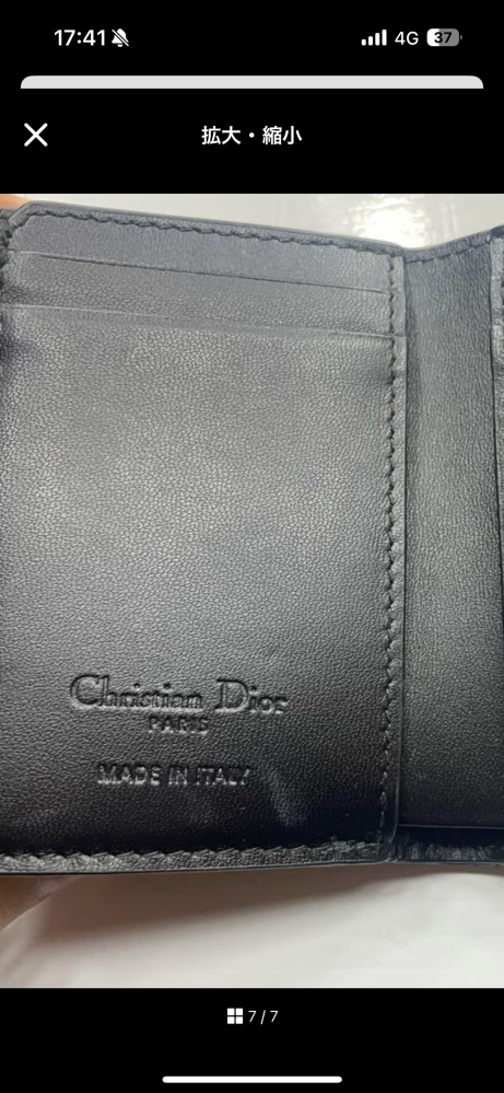 Diorの財布について質問です。 Diorのロータスウォレット エナメルのお財布なのですが、メルカリで、添付した写真のような出品を見つけました。 買おうと思っていないのでメルカリで買うななどの回答はいらないです。 ただ私が同じ商品を公式オンラインで購入していたので気になったのですが、made in Italy の位置おかしくないですか？ 私のお財布は、見えないようなところにあります。 出品者はポップアップで購入したとおっしゃっていますが、このような形もあるのでしょうか？なんだか革の素材もおかしいような気もします