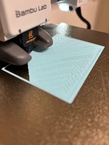 3Dプリンター初心者です。 先日、Bambu LabのA1 miniを購入しました。 2週間ほど使ったのち、画像のように印刷面が荒くボコボコした感じになるようになってしまいました。 また、印刷中もゴリゴリと音を立て、ノズルとぶつかっているようです。 原因はなんでしょうか？ 設定を変える場合、どこを変えたら良いのでしょうか？