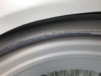 洗濯機の洗濯槽の縁に何か付いていました。 最初はホコリかと思ったのですが、非常に硬く一部はきれいに剥がれました。プラスチックがささくれたような感じです。
これは何が原因なのか、どうすればいいのか教えてください。