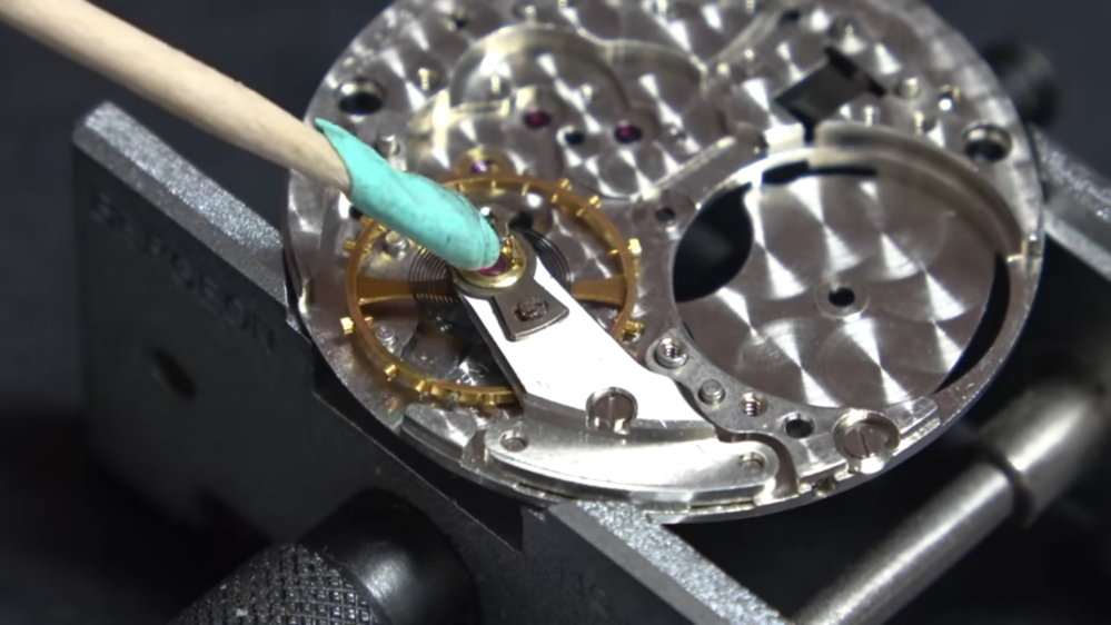 腕時計で質問です。 腕時計の修理の動画を見ているのですが、画像のうす紫色の部品て何ですか？