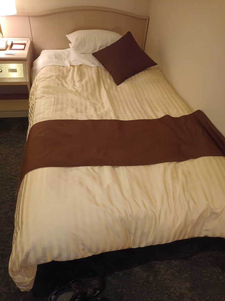ホテルにあるこういうベッドの布団の上にかけてる、足側にあるこの茶色い帯のようなものはなんですか？ 大体のホテルの布団に必ずかけられてるんですが いったいこれは何のためにどう使うためにあるのですか？