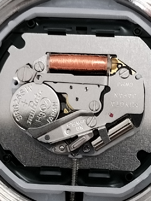 この腕時計のボタン電池を取り出すには、ピンセット等で、何処をどちらの方向に動かせば良いですか？