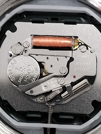 この腕時計のボタン電池を取り出すには、ピンセット等で、何処をどちらの方向に動かせば良いですか？ 
