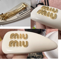 このMIUMIUバレッタは本物ですか？
 
 先日、MIUMIUのバレッタをプレゼントで頂いたのですが
 こちらを含むMIUMIUヘアクリップは偽物も多く出回っていると知りまして… 本物か分からず、付けるのを少し躊躇っております。 偽物をプレゼントするような子ではないのですが、色々調べて見ましたが本物と偽物の見分けがよく分からないので、詳しい方、お力添え頂けると幸いです……。
 よろ...