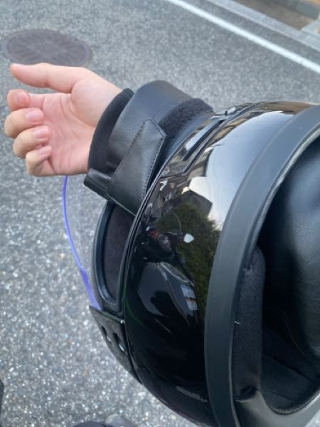 バイクのヘルメットについて、 タンデムする時に、自分のヘルメットを貸すのですが、その友達の家まで迎えに行く道中、ヘルメットを片手にくぐる？？片手にぶら下げて、運転します、すぐ近くなのでいいかと思ってるのですが、もしも警察に見つかったら何かの違反になるのでしょうか？？ 写真のような感じで運転してます。