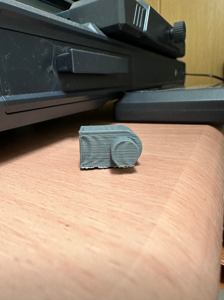 FDM式の3Dプリンターについて質問です。 出力品の平面部分が近くの突起の形状っぽく波打ってしまうのですが原因として考えられる事を教えていただきたいです。 添付写真の様に近くの丸突起の形状に平面部分が波打ってしまいます。 使用機種はNeptune 3です。