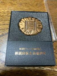 小学時代に 新潟県ジュニア美術展覧会
新潟日報美術振興賞
というのに入選し写真の賞品を貰いました。

金を持つと重さがあるのですが
本物ですか？それとも銅ですか？
