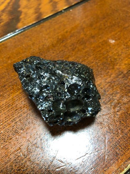 家の近くで謎の石を発見しました。 - 黒くて光沢があり穴が開いてます 