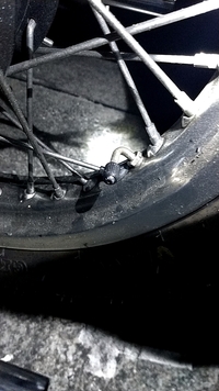 バイク w650 Kawasaki パンク チューブタイヤ

KawasakiのW650についてです！
砂利道を走った直後にパンクに気づきました…。
空気を入れたところ、どうやら写真のバルブ根本（ナットの部 分）から漏れているようです。
ナットを締めてみたのですが、漏れが少なくなるだけで、洗剤をかけると気泡ができます。
タイヤを観察しても、穴や何かが刺さっているわけでもありません...