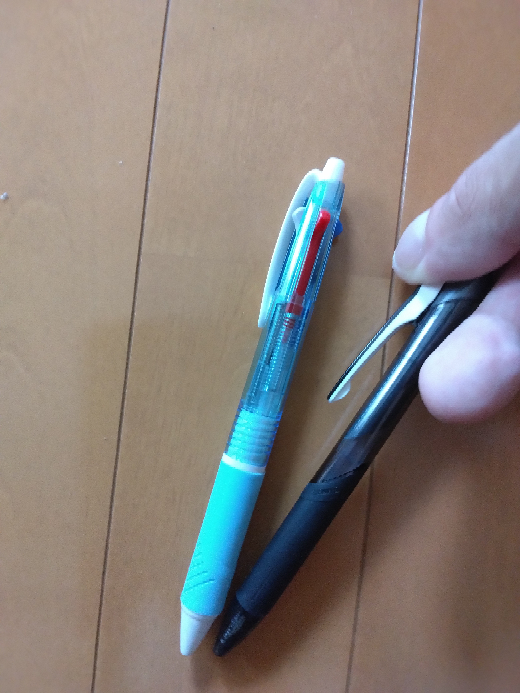 質問です。 写真の左の固定されたボールペンのはさむ物？と言えばいいのでしょうか？ 右のボールペンのように固定ではなく、写真のように指で動かして止めれる左の写真のボールペンのような3色のボールペンありませんか？ 左のボールペンのようにはさむのが固定されているのは嫌です。 右のボールペンのように動かせる物ありませんか？ ご回答よろしくお願いします。