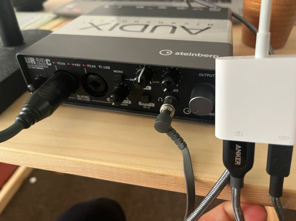 オーディオインターフェイスを使った録音について質問です。 使用しているのはSteinbergのUR22Cで、USB3.0と純正カメラアダプタを使ってiPhoneに接続して、給電と録音をしています。目的はカメラアプリでの歌動画の撮影で、コンデンサーマイクをつないで使用しているのですが、左右２チャンネルに分かれた仕様の為、片方のチャンネルの音しか録音できません。正面についているモノラル、ステレオの切り替えスイッチを押しても変わりません。この状態から、左右両方に音が聞こえるように録音するにはどうすればよいですか。iphoneにはdspMixFx UR-Cをダウンロードしていますが、カメラアプリ等との連携の仕方がわかりません。PCにつないでDAWを使った録音をし、あとから映像と編集でつなげるしか方法はないのでしょうか。 出来ればiPhoneのカメラアプリで、片耳ではない音声と映像を取りたいです。ちなみに、カメラアプリ設定の「ステレオ音声を録音」はオフにしています。 知識が浅いのでわかっていない部分も多いと思いますが、どなたかお力を貸していただけると幸いです。