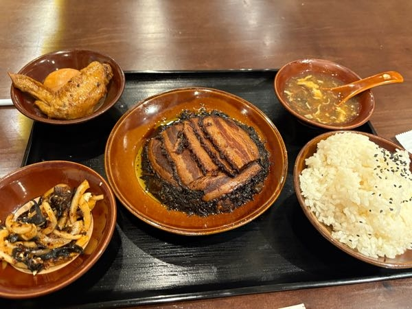 高田馬場の中華料理屋さんで、豚肉の煮物の定食をいただきました。 お客さんもほとんど中国の方、店員さんも中国人。 この豚肉の下にある、野菜の漬物のようなものと一緒に煮てあるようです。 この黒くなった野菜は、独特の風味でご飯のおかずにぴったりだったのですが、名前や料理方法がわかりません。 どなたか材料と名前を教えていただけるでしょうか。