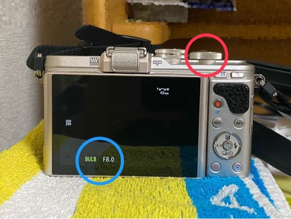 【至急】カメラについての質問です。オリンパスペンE-PL8を使っています。写真の赤マルのところをまわし続けると青マルのようにバブルが出てきてしまうのですが、これをやめる方法を教えてください。 以前は、まわし続けてもこんなことにはなっていませんでした。