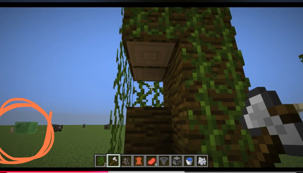 https://youtu.be/5ZxYkYdmsjc?si=ryV-kACynF0zdFME この動画、または下の画像の赤丸の中に映っている後ろのぴょんぴょん飛んでいる緑のスライムみたいなやつって何でしょうか？！ マイクラ初心者です！ 作り方とかあれば教えて欲しいですm(_ _)m