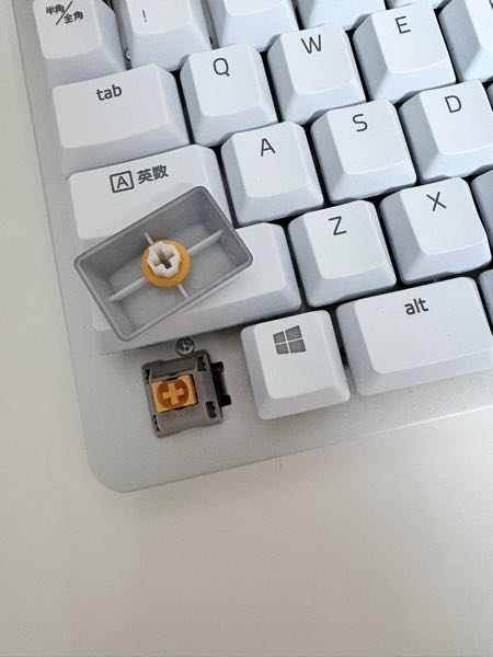 RAZERのキーボードを使用しているのですが、打鍵音がうるさく感じます。 キーキャップの裏に付属していたオレンジ色のリングを付けたら音が軽減されるという事だったのでつけてみたのですが違いがあまり分からず個人的にはリングを付けても好みの打鍵音ではありません。 私は静かな音が好きですが、このキーボードはデザインがすごく好みなので出来ればこのまま使用したいと思っているのですが、音を静かにさせたり軸を変えることは可能なのでしょうか？ 軸は外そうと思っても外れませんでした。(外し方が違うのか元々外せないものなのかは分かりません) 何か対処法お分かりの方いましたら教えていただきたいです。 こういったことは詳しくないのでどうかよろしくお願いいたします。